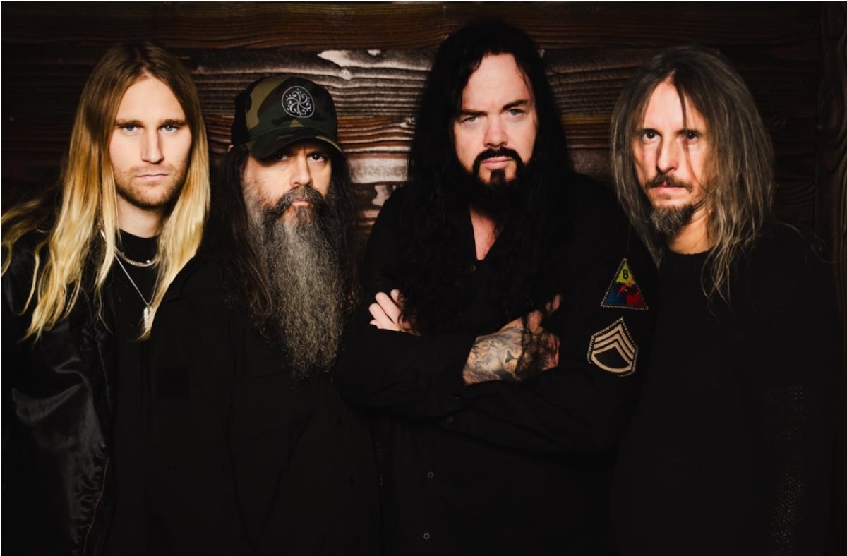 Studio promotional photo of Evergrey, photographed by Patric Ullaeus, featuring the band members posed together against a dark, atmospheric background.