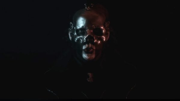 “Papa Perpetua of Ghost standing in the dark, wearing ornate papal-inspired costume and skull face paint