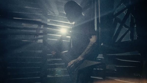 Greg Mackintosh from Paradise Lost playing electric guitar on stage.