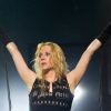Angela Gossow performing live on stage with Arch Enemy, captured mid-performance under dramatic concert lighting.