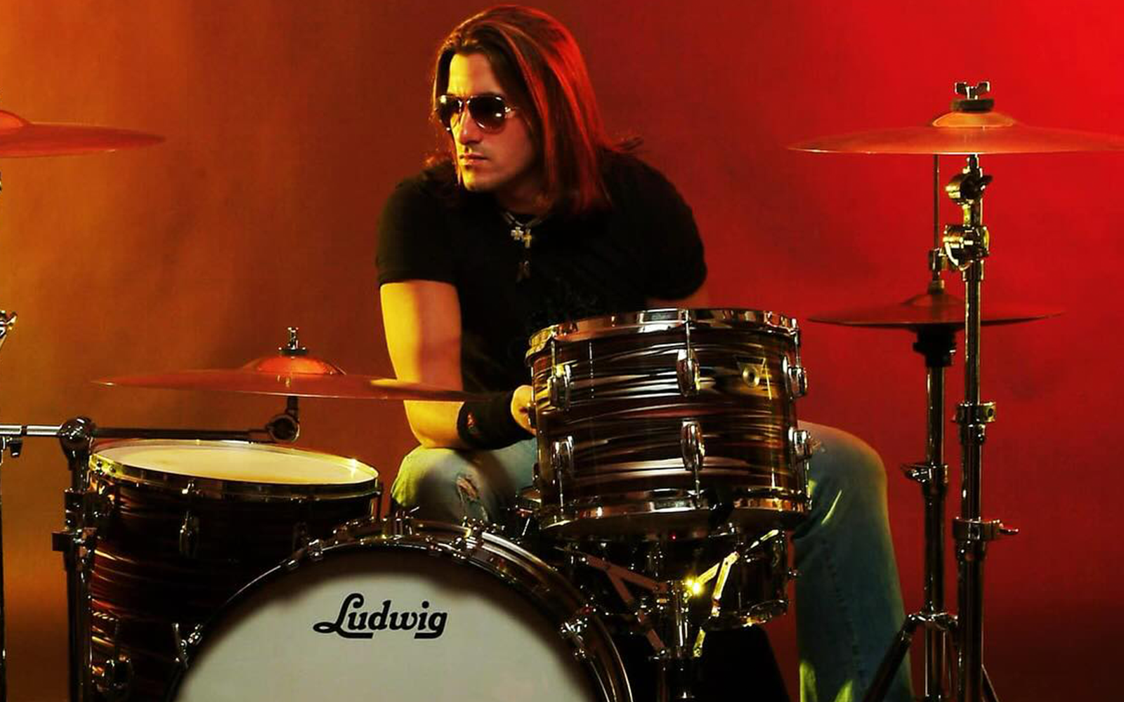 Joey Cassata sitting behind his drum kit in a promotional photo.