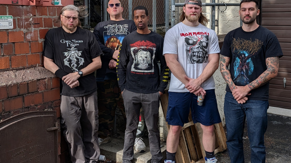 Promotional photo of atmospheric death metal band REEKING AURA, featuring all current and former members posed together