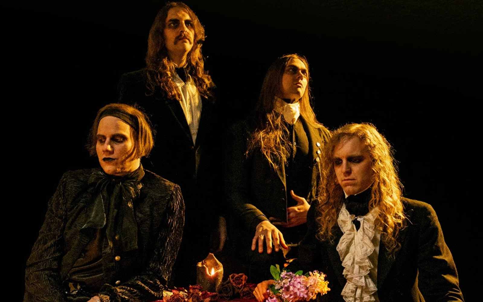 Promotional photo of the band Spell, featuring Cam Mesmer (vocals, bass, rhythm guitar, synthesizers), Al Lester (vocals, lead guitar, rhythm guitar, drums), Jeff Black (lead guitar, backing vocals), and Gabriel Tenebrae (lead guitar, synthesizers).